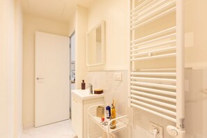 Een douche, een bidet, handdoeken, shampoo