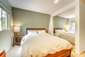 Quarto com duas camas, um espelho grande e abajures.