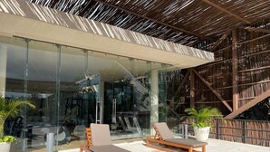 A modern outdoor seating area with two lounge chairs and potted plants.