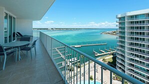 Un balcon avec vue sur l’océan et un port de plaisance.