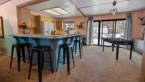 Eine geräumige Küche mit Bar, Hockern und einem Kicker.