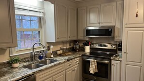 A kitchen with white cabinets, a stainless steel stove, a microwave, and a sink. - LU Commencement Rental - Easy 15 minute drive to LU campus. (Forest)