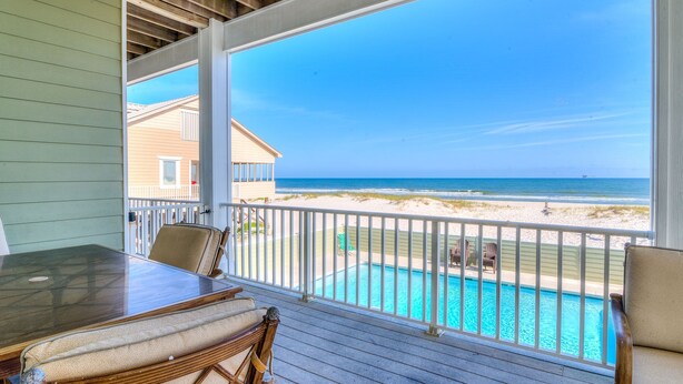 A covered deck with a view of a beach and a pool. - Beach Castle, West. 8BR. Sleeps 27. Large Pool! Great decks,, Beachfront. Value! (Gulf Shores)