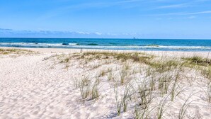 A beach with sand dunes and the ocean. - Beach Castle, West. 8BR. Sleeps 27. Large Pool! Great decks,, Beachfront. Value! (Gulf Shores)