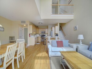 A spacious living area with a dining table, chairs, a sofa, and a kitchen in the background. - Spacious Beach Retreat • Steps to Boardwalk (Seaside Heights)