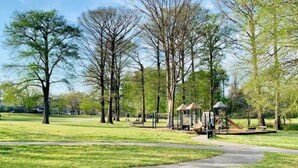 Een park met een speeltuin, wandelpaden en bomen.