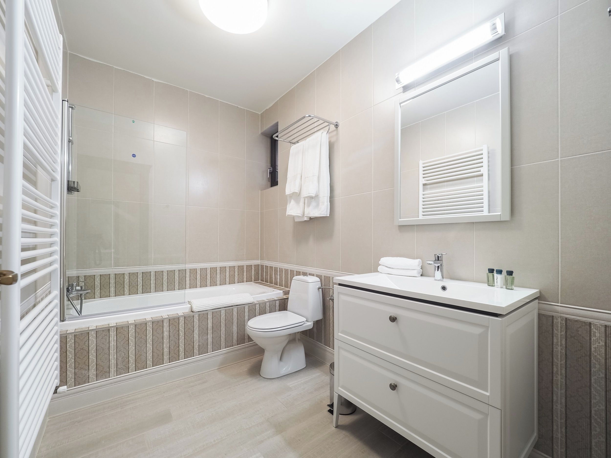 Un baño moderno con bañera, inodoro y tocador.