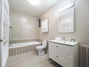 A modern bathroom with a bathtub, toilet, and vanity. - Boutique Central Sibiu (Sibiu)