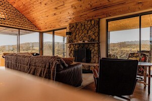 Una habitación con una cama grande, una pared de piedra, una chimenea y vistas al paisaje.