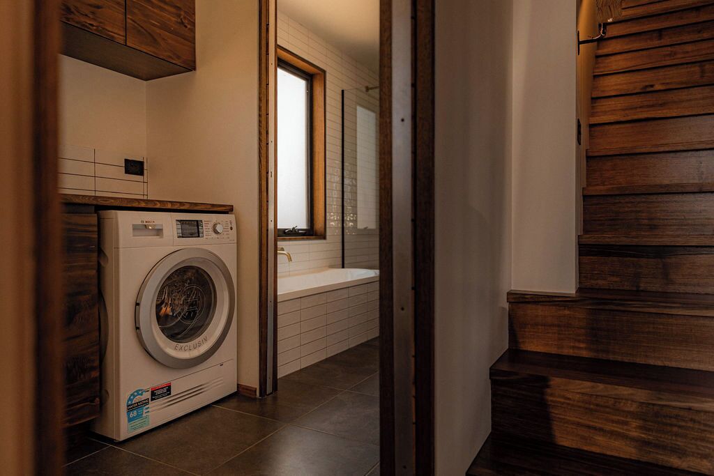 A laundry area with a washing machine, a sink, and a window.