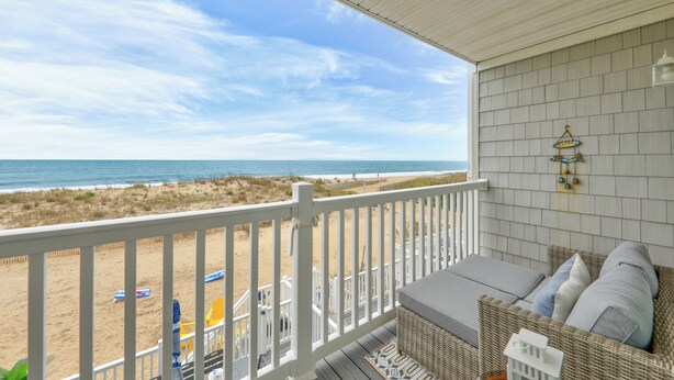 Ein Balkon mit Blick auf Strand und Meer.