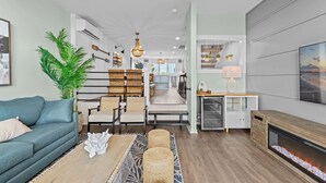 Ein modernes Wohnzimmer mit einer Couch, Sesseln, einem Couchtisch und einem Kamin.