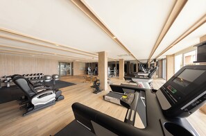 Une salle de sport moderne équipée de matériel d’exercice, d’un tapis de course et d’un rameur.