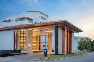 Entrada moderna de hotel con un cartel que indica las direcciones a la recepción y al estacionamiento.