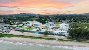 A coastal hotel with multiple buildings, a beach, and a view of the surrounding landscape. - Eastin Resort Rayong (Ban Chang)