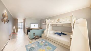 A children's room with bunk beds, a desk, and a play area.