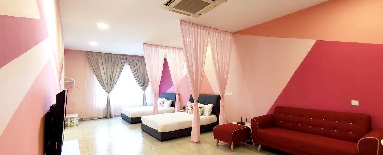 Una habitación de hotel moderna con dos camas, un sofá rojo y una televisión.