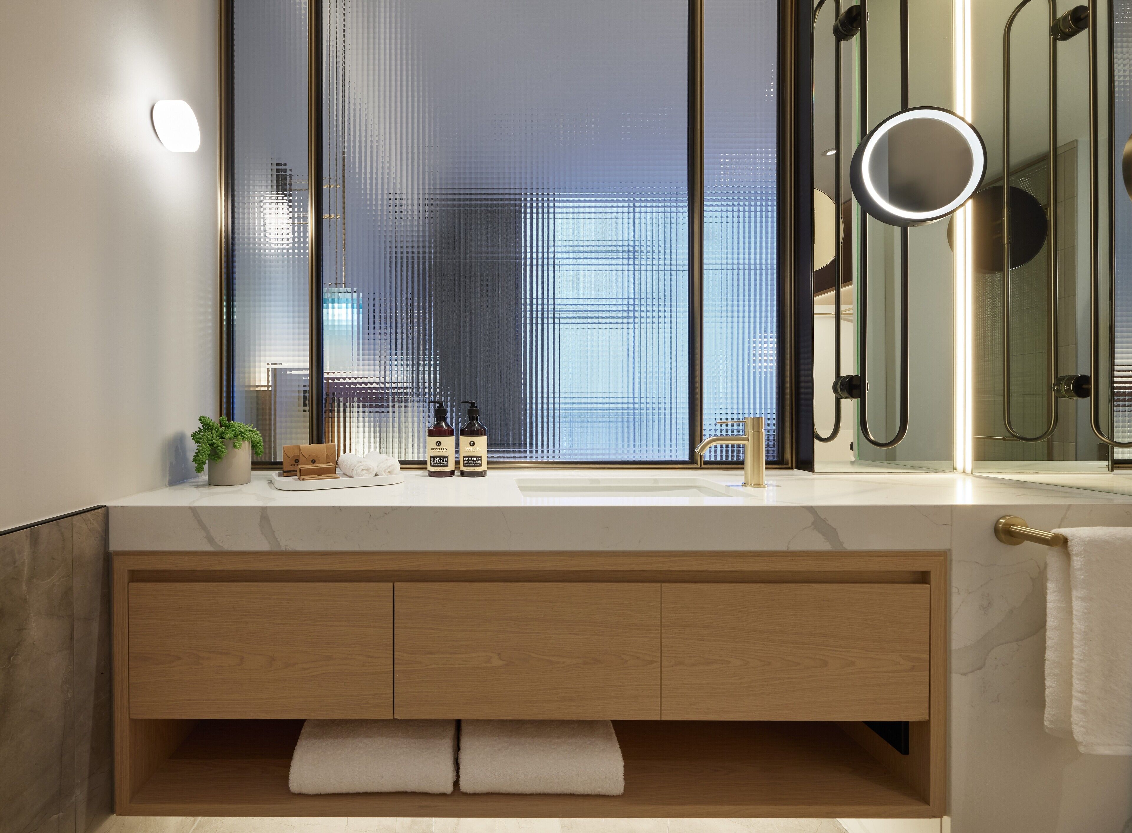 A modern bathroom with a large mirror, a built-in sink, and a shower area.