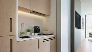 Una cocina moderna con armarios de madera, un lavamanos integrado, una cafetera y un ventanal amplio.