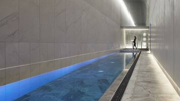 Relax by the sleek pool surrounded by a uniform tile pattern.