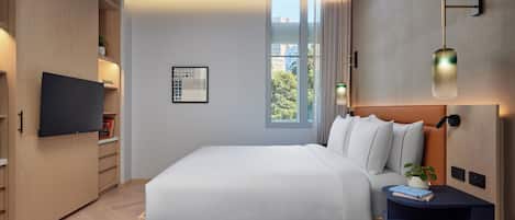 Una habitación de hotel moderna con una cama grande, armario empotrado, televisor de pantalla plana y vistas al exterior.