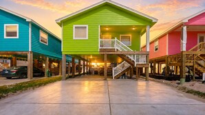 A colorful house with a green front, a porch, and a staircase. - Private Pool, Pet Friendly, Parking for 5 Vehicles (Port Aransas)