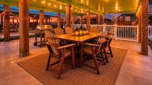 An outdoor patio with a wooden table and chairs, string lights, and a grill. - Private Pool, Pet Friendly, Parking for 5 Vehicles (Port Aransas)
