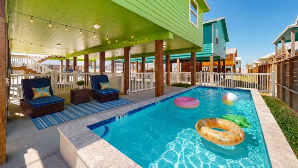 A pool area with lounge chairs, a covered deck, and a clear blue pool. - Private Pool, Pet Friendly, Parking for 5 Vehicles (Port Aransas)