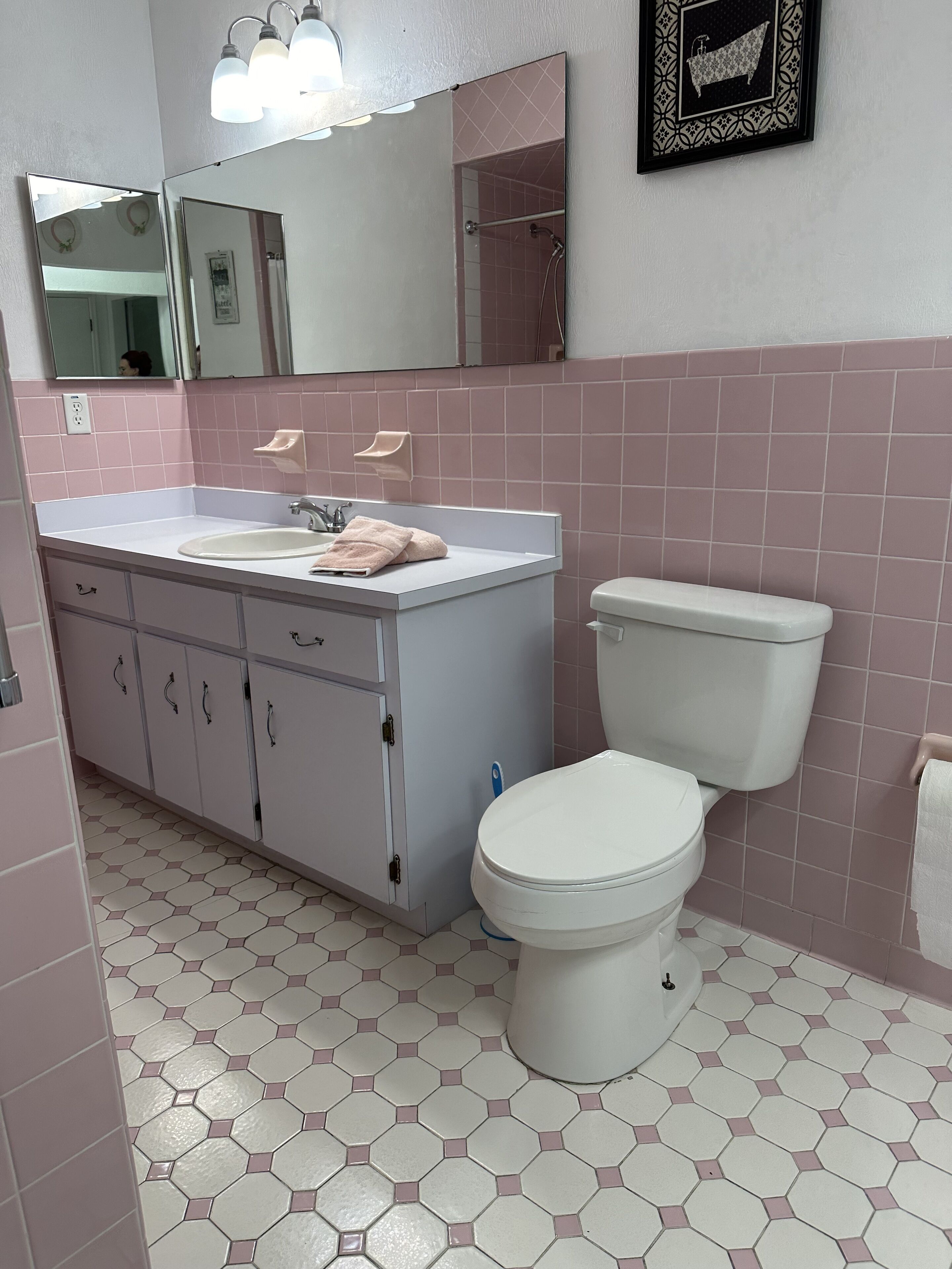 A bathroom with a white sink, a toilet, and a mirror.