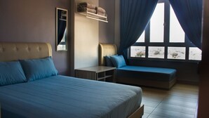 A bedroom with a large bed, a smaller bed, a bedside table, a shelf with towels, and a window with curtains. - Octagon Premium Ipoh Homestay (Ipoh)