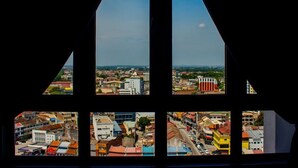 A view through a window with multiple panes, each displaying a different urban landscape. - Octagon Premium Ipoh Homestay (Ipoh)