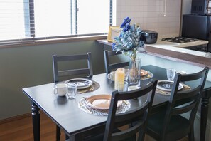 Enjoy meals in this cozy dining area with a table for four, featuring a beautiful centerpiece and comfortable seating.