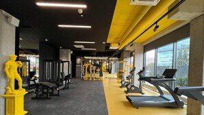 Un gimnasio con equipo de ejercicio, una estatua y una cinta de correr.