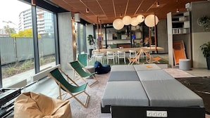 Un intérieur moderne doté d’une grande fenêtre, d’un coin repas et de différents espaces pour s’asseoir.