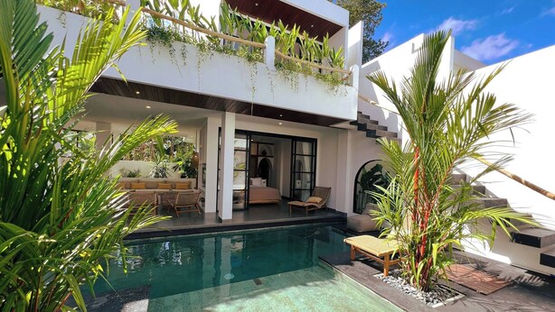 A modern two-story house with a swimming pool, outdoor seating, and lush greenery. - Casa Carolina Bali - Great 3 Bdr - Tumbak Bayuh Canggu (Canggu)