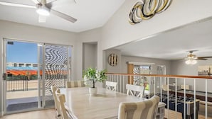 A dining area with a large table, chairs, and a potted plant. There is a view through the glass door to the outside. - Prime Location, Perfect Stay: Stadium Proximity Home with Pool & Entertainment! (Glendale)