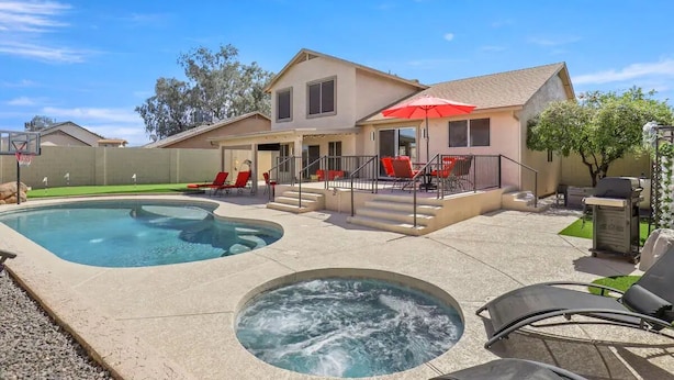 A two-story house with a swimming pool, hot tub, and outdoor seating area. - Prime Location, Perfect Stay: Stadium Proximity Home with Pool & Entertainment! (Glendale)