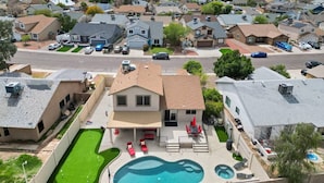 A residential area with a house featuring a swimming pool, a covered patio, and a view of the surrounding neighborhood. - Prime Location, Perfect Stay: Stadium Proximity Home with Pool & Entertainment! (Glendale)
