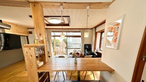 Ein Holztisch mit drei Tellern, einem Stuhl und einer Blumenvase.