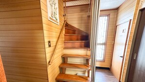 Eine Holztreppe mit Metallgeländern, die zu einer Zwischenebene führt.