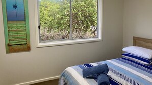 A bedroom with a bed, a window with a view of trees, and a painting on the wall. - Hideaway By The Lake - The perfect lakeside holiday location!
 (Nords Wharf)
