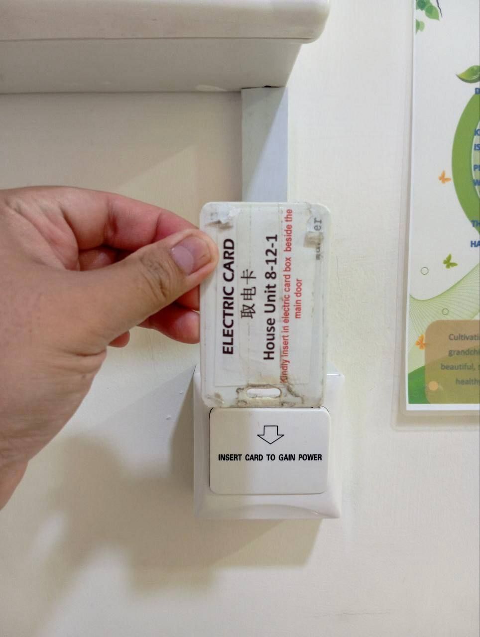 A hand holding an electric card with instructions to insert it to gain power.