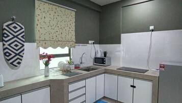 Cozinha com micro-ondas, pia e ventilador de teto.