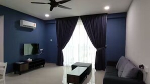 A modern living room with a flat-screen TV, a ceiling fan, and a large window with curtains.