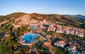 Un resort con varias piscinas, un campo de golf y un paisaje montañoso.