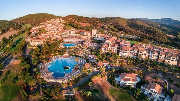 Un complexe hôtelier doté de plusieurs piscines, d’un parcours de golf et offrant un paysage vallonné.