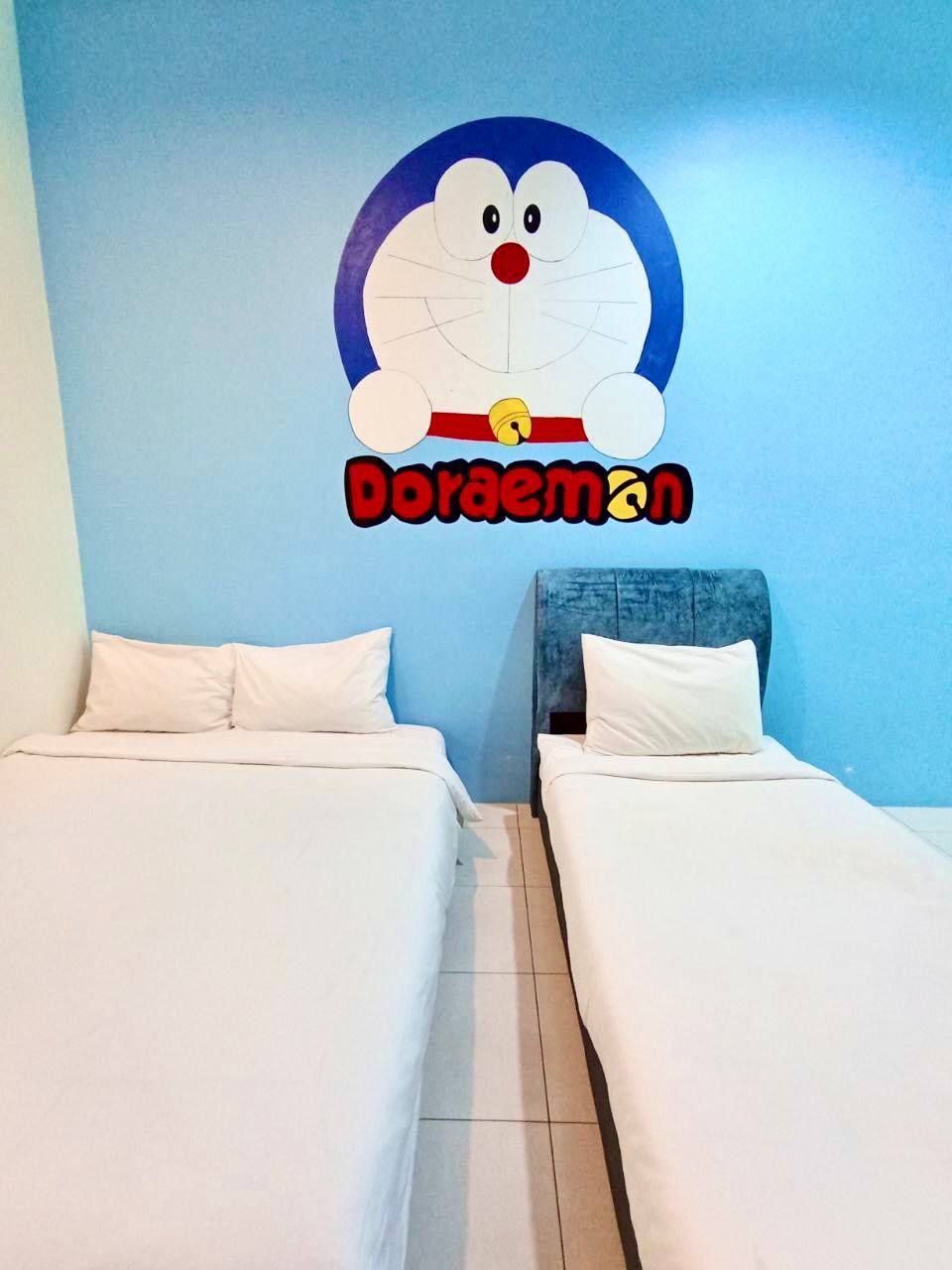 Ein Zimmer mit zwei Betten, einer blauen Wand und einem Wandbild von Doraemon.