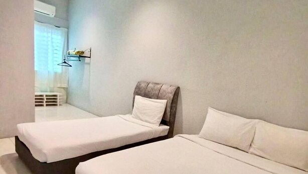 A modern hotel room with two single beds, a small desk, and a window with curtains. - Animation Homes I Meru Raya IPOH I by Grab A Stay l 16pax max (Ipoh)