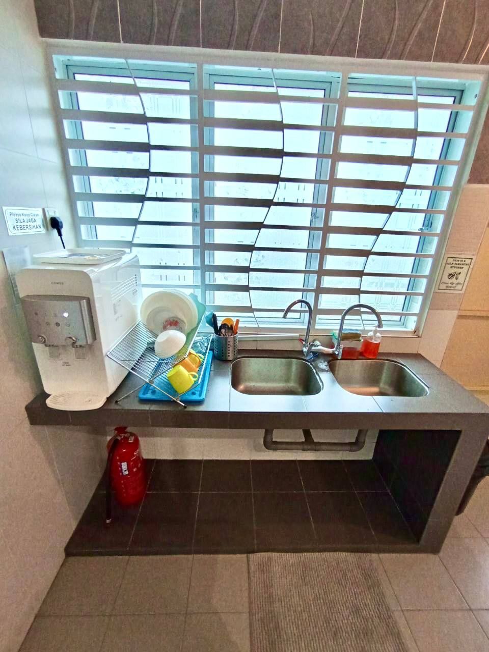 A kitchen with a sink, a coffee maker, a dish rack, and a window with blinds.