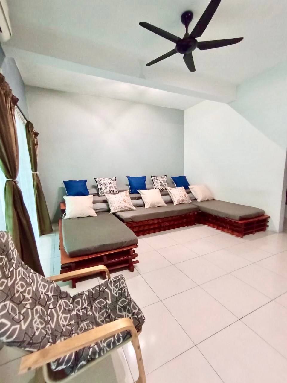A modern, well-lit room with a sectional sofa, a small table, and a ceiling fan.